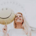Macht-des-Lächelns-Tag, lächelnde Frau mit Smilie-Ballon